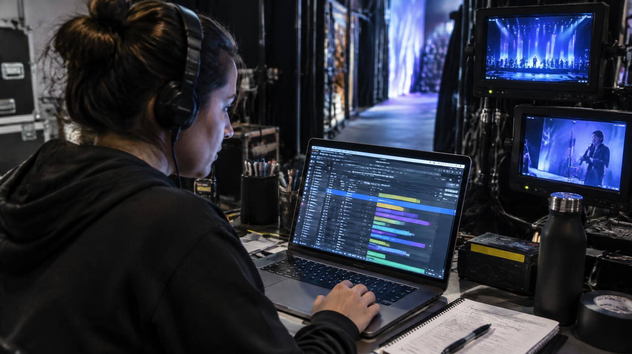 Technician monitoring a run-of-show timeline on a laptop backstage