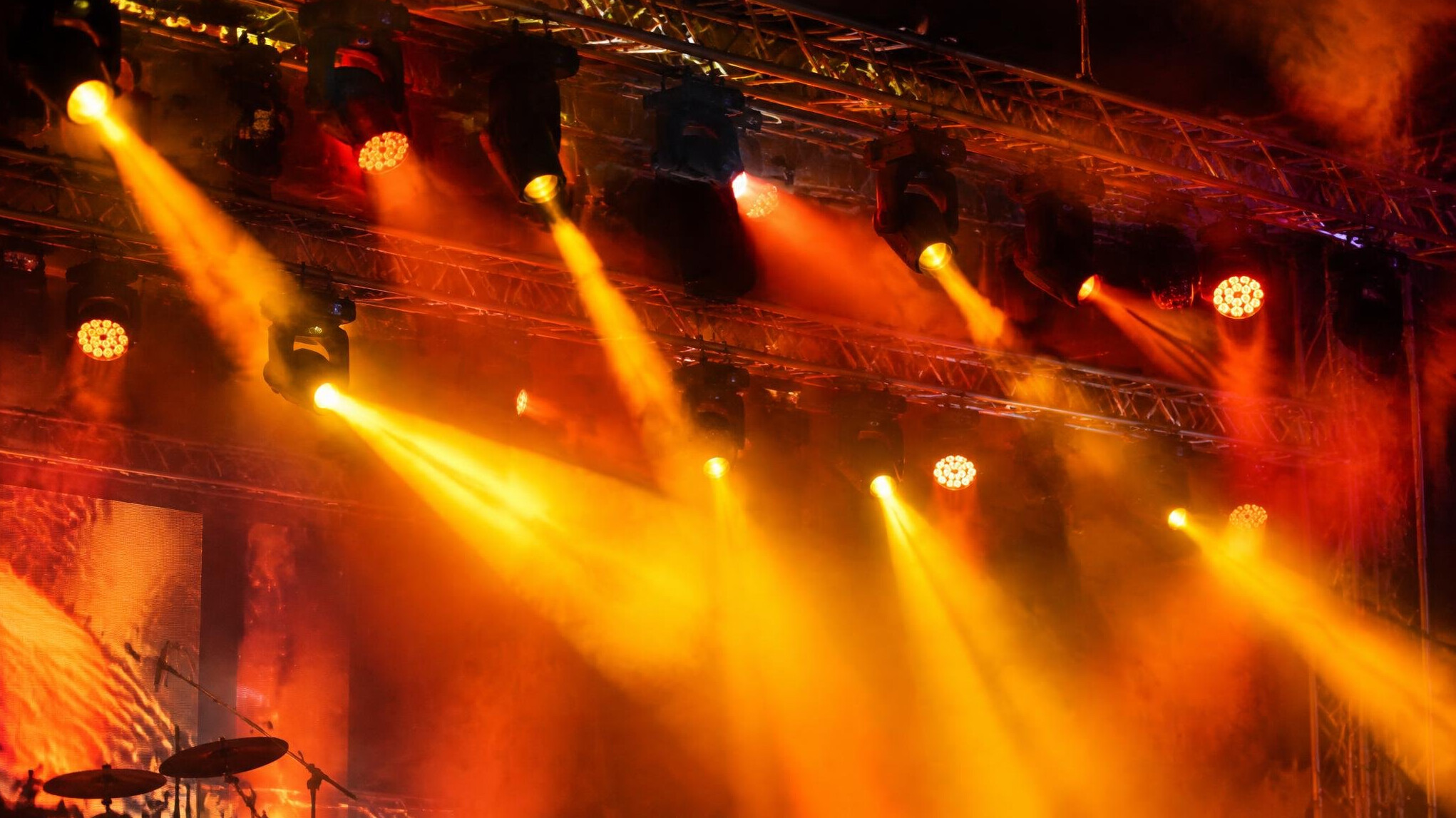 Colorful stage lighting rig changing colors above a concert stage